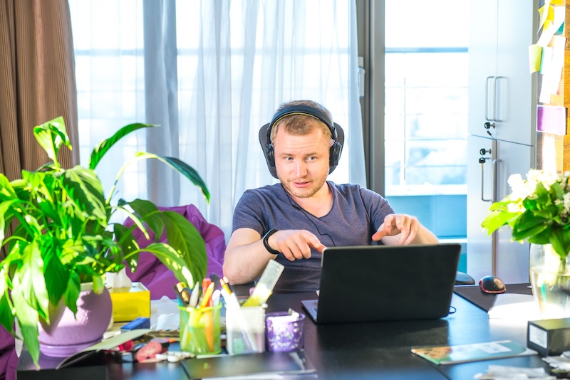 L'homme dans les écouteurs en télétravail a une réunion vidéo