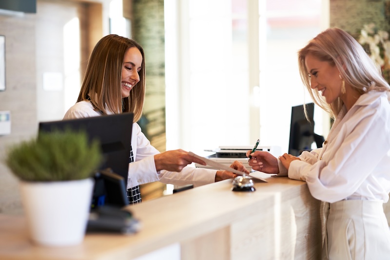 Réceptionniste et femme d’affaires à la réception d’hôtel